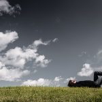 human laying on ground thinking