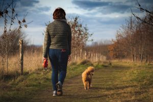 woman walking with dog in nature