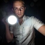 man in dark with flashlight