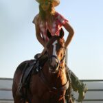 Cowgirl mounting a horse